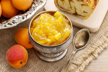 Bowl of apricot jam and apricot pastry in the background