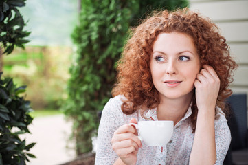 Gorgeous woman holding cup of coffee in a cafe