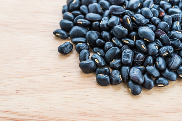 Black beans on wooden background