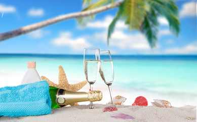 Champagne flutes on sunny beach © Lukas Gojda