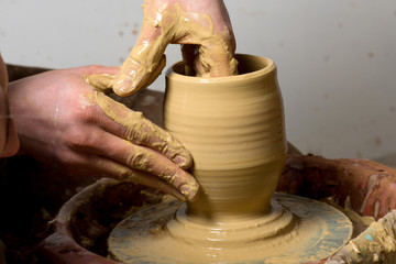 hands of a potter, creating an earthen jar