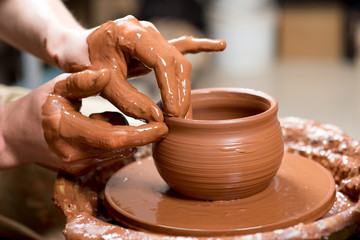 hands of a potter, creating an earthen jar