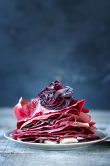 Sweet red pancakes on wooden table.