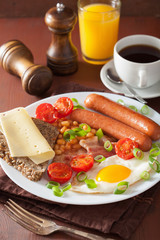 english breakfast with fried egg sausages bacon tomatoes beans