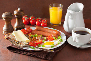 english breakfast with fried egg sausages bacon tomatoes beans