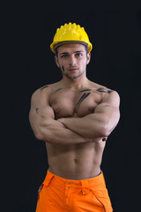 Muscular young construction worker shirtless wearing hardhat