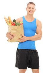 Young athlete holding a bag full of groceries