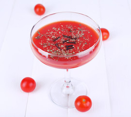 Tomato juice in glass goblet and fresh tomatoes