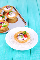 Tartlets with greens and vegetables with sauce on plate and