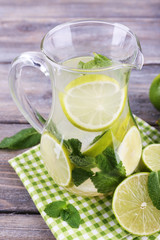 Lemonade in pitcher on wooden background