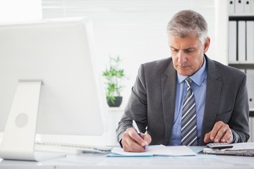 Focused businessman writing something down