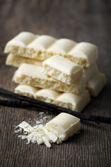 Fototapeta na wymiar Tasty white porous chocolate with vanilla sticks