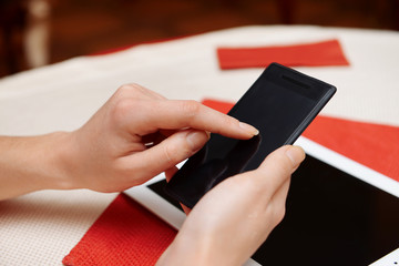 Woman with mobile phone and tablet computer in cafe shop