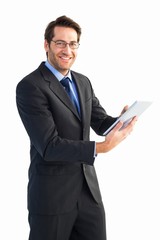 Businessman looking at the camera while using his tablet