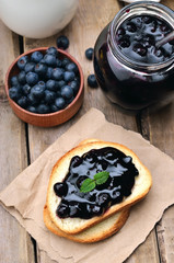 Bread with blueberry jam on wooden table