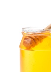 honey jar on white background with wooden honey dipper inside