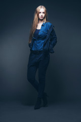 Woman jeans winter fashion. Long blonde hair. Studio shot agains