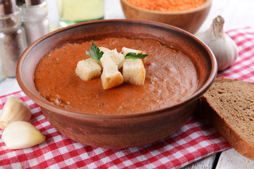 Delicious lentil cream-soup on table close-up