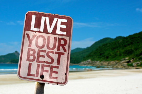 Live Your Best Life sign with a beach on background