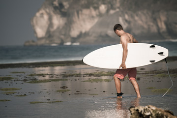 Surfer with surfboard on the beach