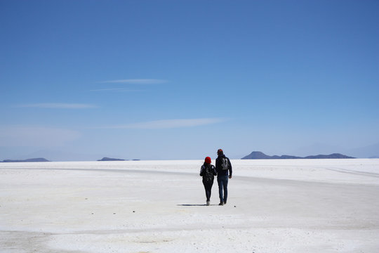 Tourists walk in a salt desert of Salar de Uyuni, Bolivia