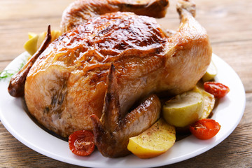 Delicious baked chicken on plate on table close-up