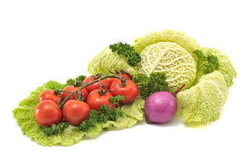 Cocktail tomatoes, savoy cabbage and purple onion on a white bac