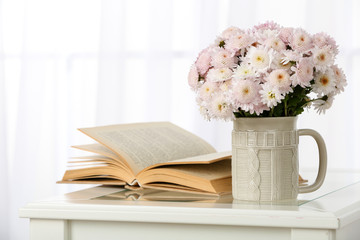 Beautiful bouquet of flowers in cup on window background