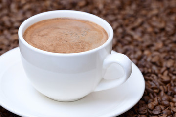 Obraz premium cup of coffee on a coffee beans background