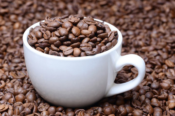 cup with coffee grains on a coffee beans background