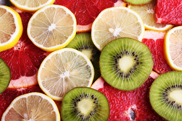 Fototapeta na wymiar Ripe slices lemon, kiwi and grapefruit close-up background