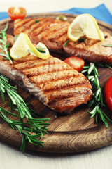 Grilled salmon with spices on cutting board on wooden