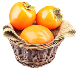 Ripe persimmons in wicker basket isolated on white