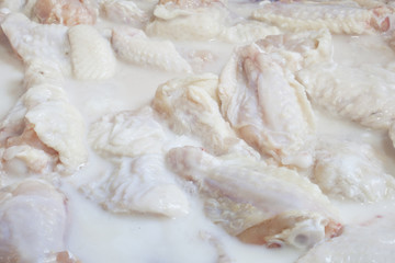 Obraz na płótnie Canvas Raw Chicken Wings marinating in buttermilk