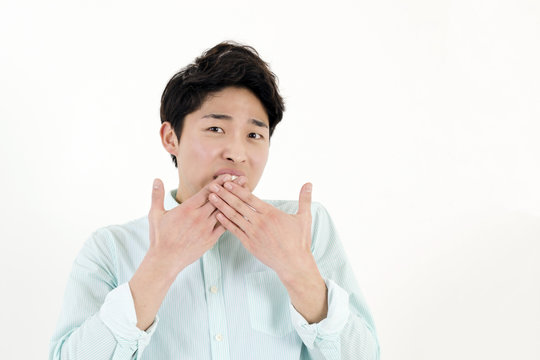 Shocked young man covering mouth with hands