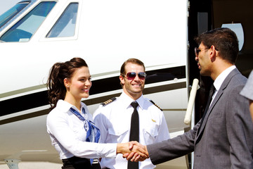 Stewardess and pilot greeting passenger