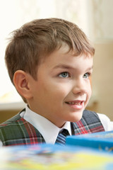 Pupil in uniform sitting at desk in school classroom