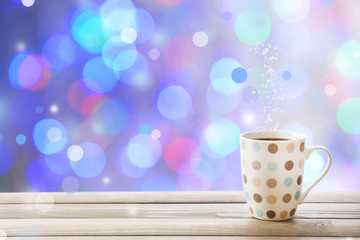 Cup of hot drink on bright background