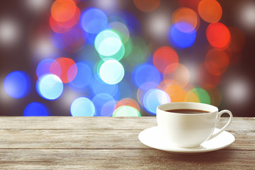Cup of hot drink on bright background