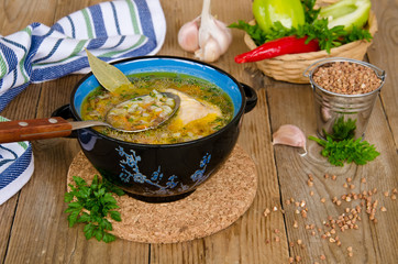 Soup with buckwheat groats on a wooden background