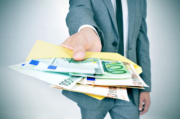 man giving an envelope full of euro bills