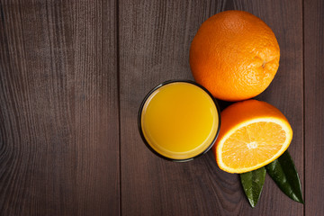 fresh orange and glass with juice on the wooden background