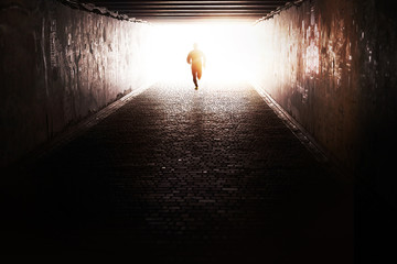 Man running through the tunnel in the sun - 73805678