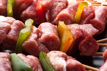 Spiedini di carne di vitello crudi su un piatto