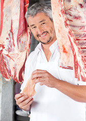 Butcher Holding Chicken Meat In Shop