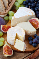 Cheese plate. Variety of cheese sorts with grapes and figs