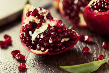 Open fresh ripe pomegranates on wooden background