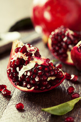 Open fresh ripe pomegranates on wooden background