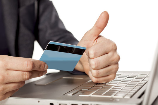 Female hands holding  a credit card and showing thumbs up