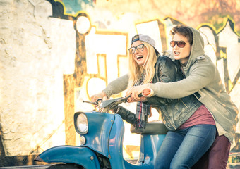 Fototapeta na wymiar Young couple in love haviing fun on a vintage scooter moped